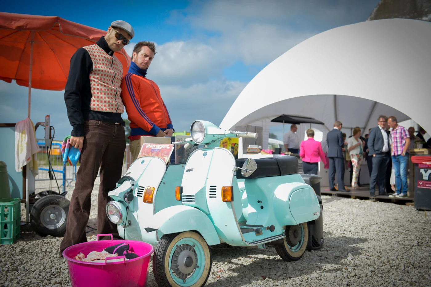 Twee mannen bij een mintgroene scooter tijdens het Midsummerfeest van NOM